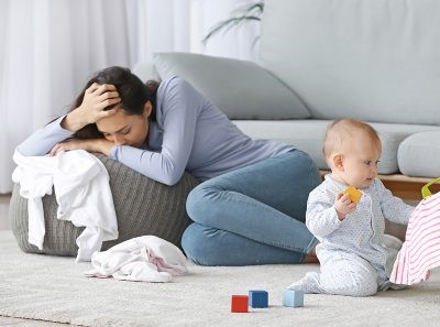 דיכאון אחרי לידה - אמא עצובה ותינוק משחק